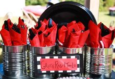 some tin cans with red napkins in them and a sign that says grease rock tools