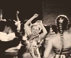 a woman dancing with other people behind her