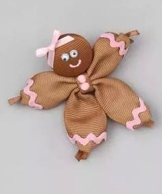 a brown and pink bow with a smiling face on it's back, sitting on top of a gray surface