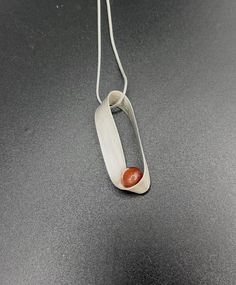 "This series was inspired by the mathematical concept of a mobius strip, a geometrical curiosity which has only one surface and one edge. It is often used as a symbol for infinity.  This necklace is created using a strip of Argentium sterling silver.  I solder a post and then glue a half-drilled stone on, creating the illusion of floating, but the stone is actually very secure.  This pendant comes on an 18\" sterling silver snake chain. (Convo me if you are interested in purchasing the pendant w Modern Carnelian Jewelry With Polished Finish, Modern Orange Necklace As Gift, Modern Orange Necklace For Gift, Modern Carnelian Jewelry As Gift, Mobius Strip, Carnelian Stone, Silver Snake Chain, Snake Chain, Pendant Necklaces