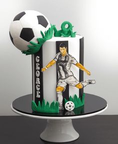 a soccer themed cake with a man kicking a soccer ball on the top of it