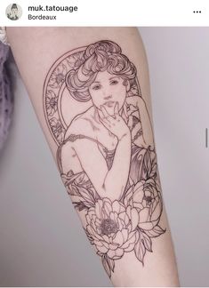 a woman's arm with a tattoo on it and flowers around the arm area