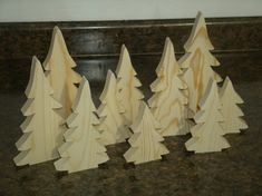 four wooden christmas trees sitting on top of a counter