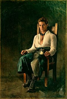 a man sitting in a chair with his legs crossed on the ground, wearing boots and a white shirt