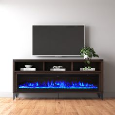 an entertainment center with a television and blue flames