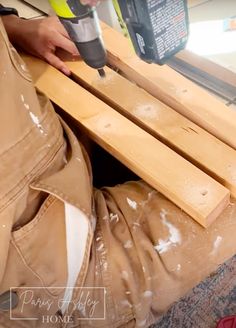 a person using a power drill to cut wood planks with a sanding machine