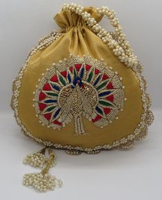 "artisan handmade golden zardosi and thread embroider art deco peacock silk fabric handbag potli bag for woman | indian wedding potli bag Material: Silk Package Contents: As per quantity purchased Size: 10\" x 8\" Designed with the heart, this beautiful Potli or batawa bag are eye catchy and made of premium material. Key Features: Embroidery art work This potli is good match with both Indian and western outfits and are superb for wedding and festive parties This would be best complement to your Cheap Handmade Traditional Shoulder Bag, Traditional Gold Shoulder Bag For Festivals, Traditional Gold Pouch For Festive Season, Bohemian Gold Potli Bag For Festive Season, Traditional Gold Shoulder Bag With Handwork, Bollywood Style Gold Festive Shoulder Bag, Golden Embroidered Fabric With Handwork For Festivals, Traditional Gold Embroidery Potli Bag, Traditional Festive Gold Clutch