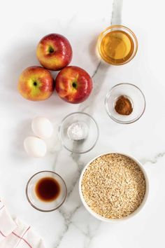 ingredients for an apple pie laid out on a marble counter top, including apples and oatmeal