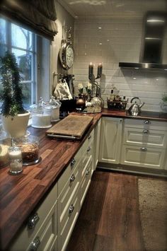 a kitchen with wooden counter tops and white cabinets