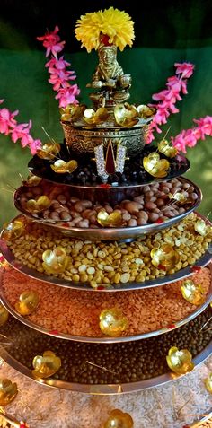 a tiered cake with flowers and rocks on it's bottom, surrounded by other decorations