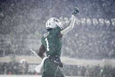 a football player catching a ball in the snow