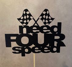 a cake topper with the words need four speed written in black and checkered flags