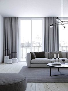 a living room filled with furniture and a large window covered in grey drapes