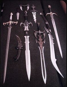 there are many different types of knives on the table with skulls and swords in them