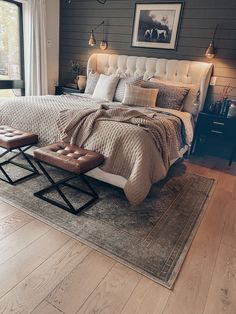 a bedroom with a bed, ottoman and window in the corner that overlooks an outdoor patio