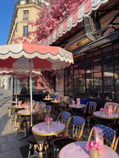 tables and chairs with umbrellas on the sidewalk