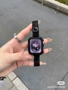 a person holding an apple watch in their left hand, with hello kitty on the screen