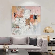 a living room with a couch, coffee table and painting on the wall above it