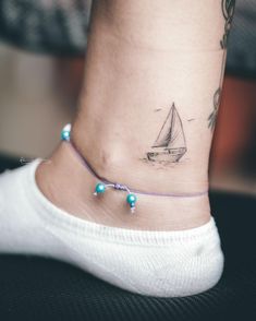 Unique & Cute Travel Tattoo Ideas For Women Exploration Tattoo Ideas, Sailing Boat Tattoo Simple, Minimalist Ship Tattoo, Fine Line Sailboat Tattoo, Sailing Tattoos For Women, Nautical Tattoo For Women, Cruise Tattoo Ideas, Small Boat Tattoo, Small Sailboat Tattoo