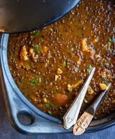 a pot full of food with spoons on the side