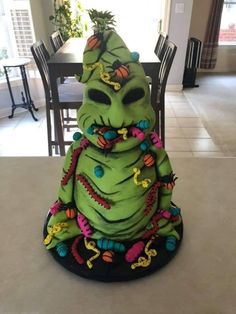 a large green cake sitting on top of a table next to a dining room table