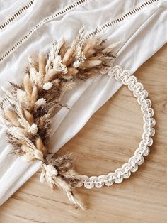 a white doily with some brown feathers on it next to a piece of cloth