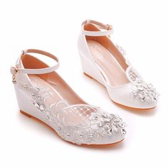 a pair of white shoes with lace and bows