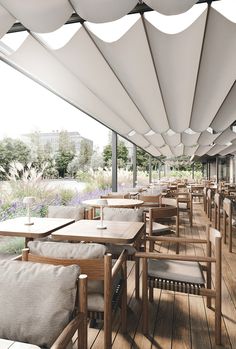 an outdoor dining area with wooden tables and chairs under white awnings on a sunny day