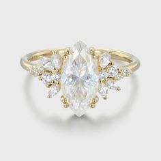 a gold ring with an oval cut diamond surrounded by smaller round diamonds on each side