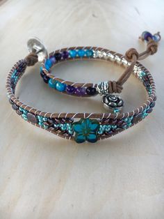 Silver Turquoise, Agate, Flower, Hematite Leather Double Wrap Bracelet This Bracelet Features.... Genuine Natural color Round Leather 2mm Beautiful 6mm Turquoise Shell Beads  6mm Purple Agate Beads with such colorful designs 6mm Hematite Beads Superduos(2 hole) beads 14 mm Glass Flower Bead 2 square purple tile beads Silver Edelwiss Flower Button 20mm This Bracelets has 12" of beading with 2 button hole type adjustments at 13 1/2" and 15" and wraps around your wrist twice. The length listed is the inside circumference when the bracelet is clasped. This bracelet will fit a size 6 1/2"-7" wrist comfortably. Agate transforms negativity into positivity. Agate enhances mental function and improves concentration. Agate is a protection and good luck stone, helps balance, and gives us strength to Agate Beaded Bracelets, Purple Tile, Jewelry Making Business, Stone Bead Jewelry, Purple Wrap, Super Duo, Flower Button, Double Wrap Bracelet, Cord Jewelry