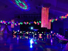 an empty dance floor is lit up with colorful lights