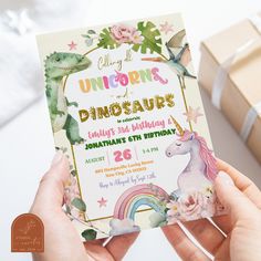 a person holding up a birthday card with an image of a dinosaur and rainbow on it