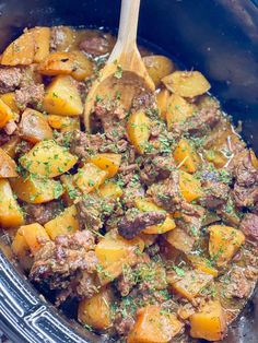 a crock pot filled with meat and potatoes, garnished with parsley