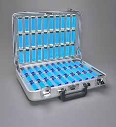 an open suitcase with blue tubes inside on a gray surface and the lid is closed