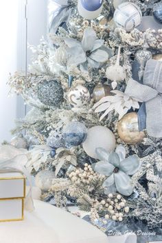 a white christmas tree with silver and gold ornaments