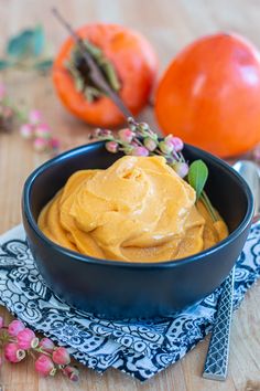 a blue bowl filled with hummus on top of a wooden table next to tomatoes