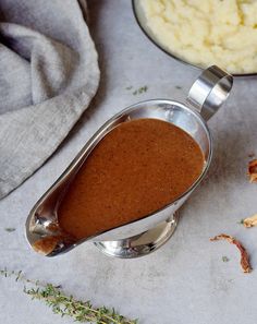 there is a gravy in a bowl next to other food on the table