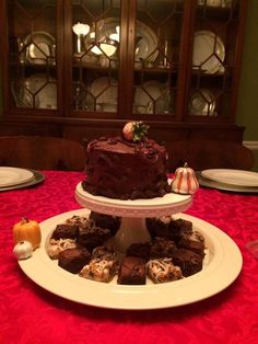 three tiered cake sitting on top of a white plate next to other desserts