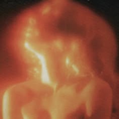 a blurry image of a woman's torso in red and orange light with the words, i am not sure what this is