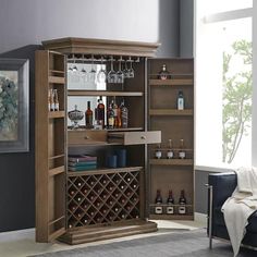 a living room with a bar and wine glasses on the shelves