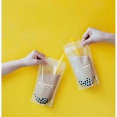 two people holding plastic cups in their hands on a yellow background with the words flipper's printed on them