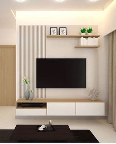 a modern living room with white walls and black table in front of the flat screen tv