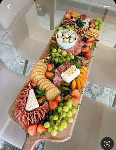 a wooden table topped with lots of different types of cheese and crackers on top of it