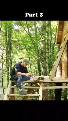 a man sitting on top of a wooden platform in the woods