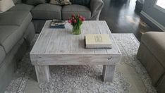 a living room with gray couches and a coffee table in front of a large window