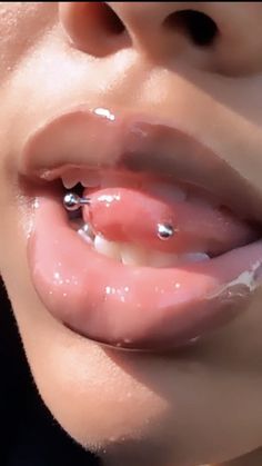 a close up of a person's mouth with piercings on it and their tongue