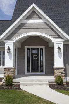 a gray and white house with a wreath on the front door