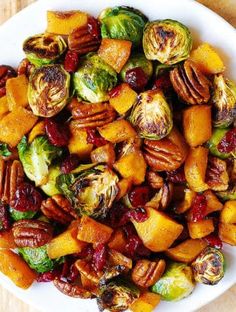 a white bowl filled with brussel sprouts and nuts