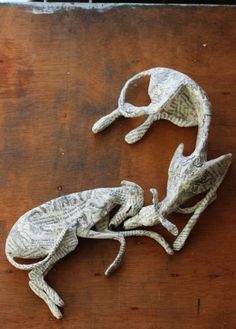 two paper mache lizards sitting on top of a wooden table