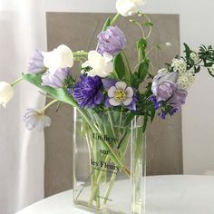 a vase filled with purple and white flowers